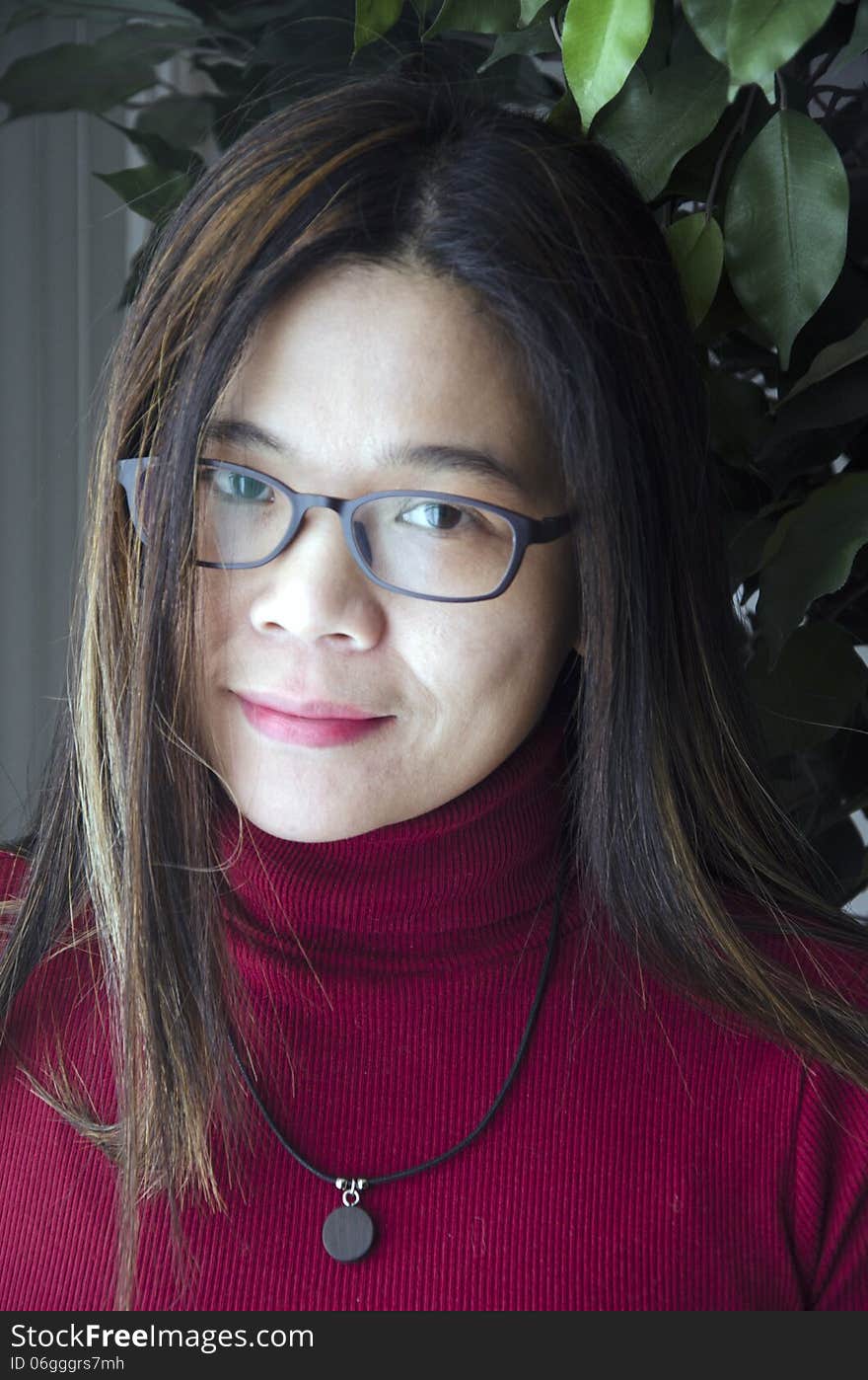 A young asian woman waiting patiently by the window. A young asian woman waiting patiently by the window.