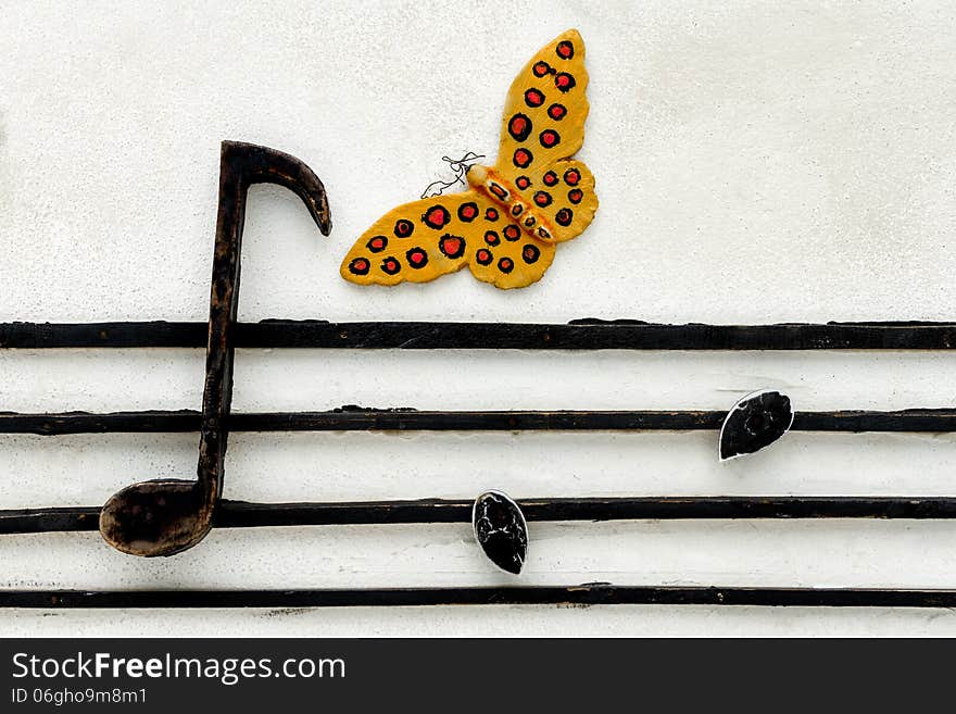 Butterfly and musical note on concrete wall