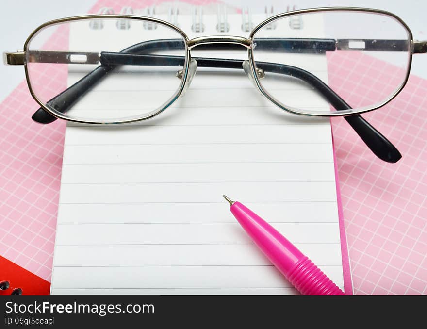 Pink pen notebook and glasses empty message