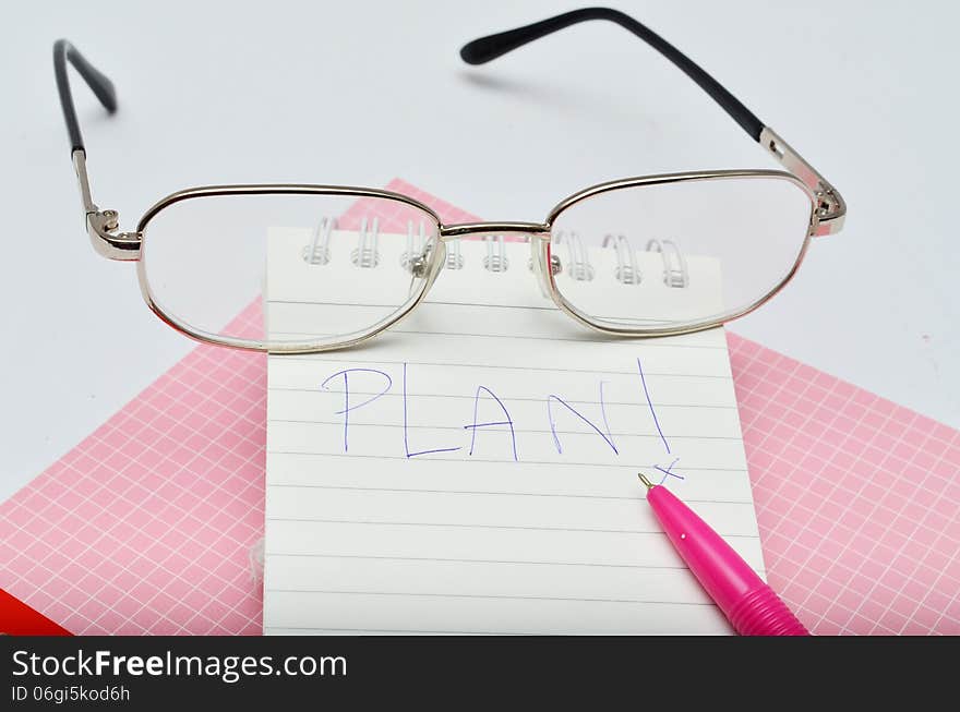 Word Plan messege on pink pen notebook with glasses