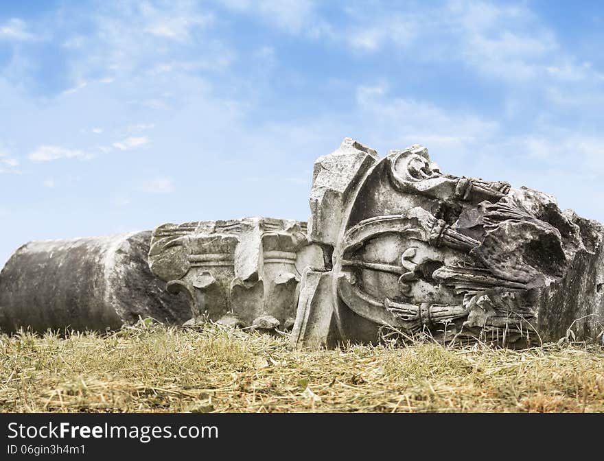 Felled ancient columns on sky background