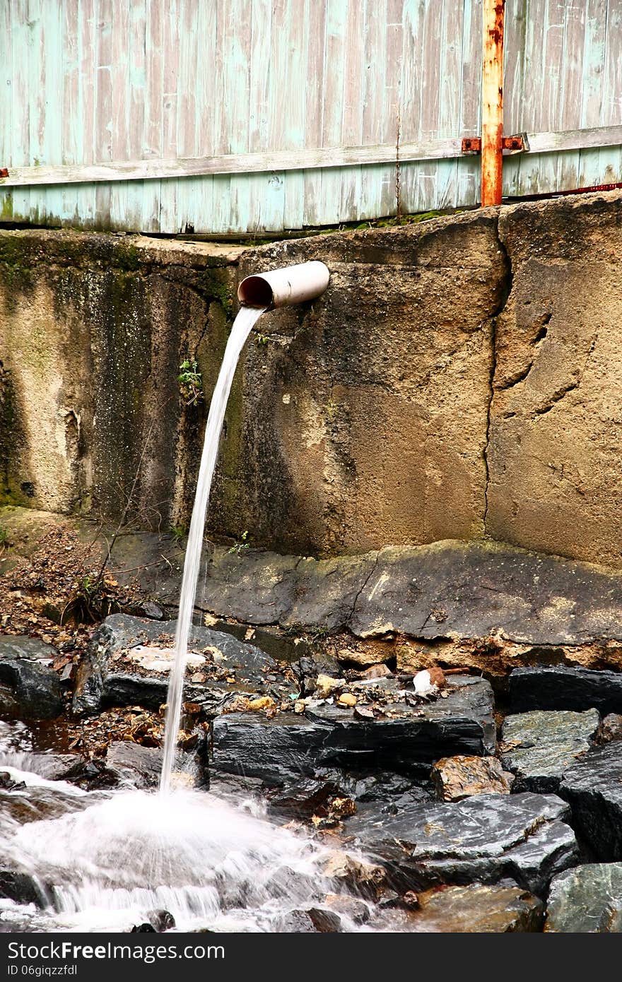 Water flows from the pipe. Water flows from the pipe