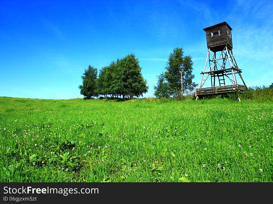 Wooden shelter for hunters on the green between