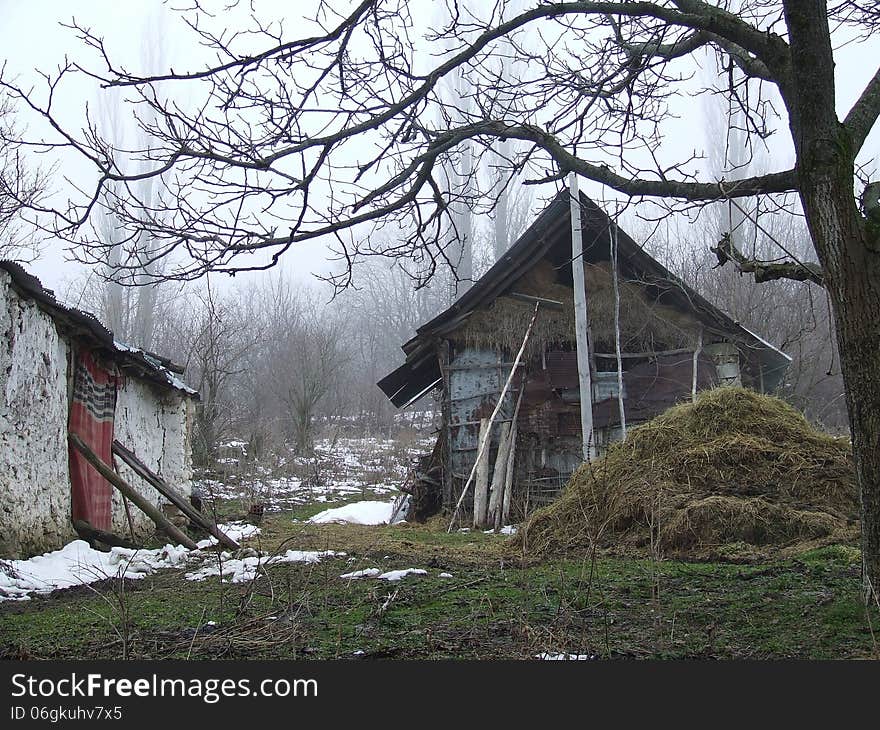 Barn in the woods with snow and hay in front. Barn in the woods with snow and hay in front