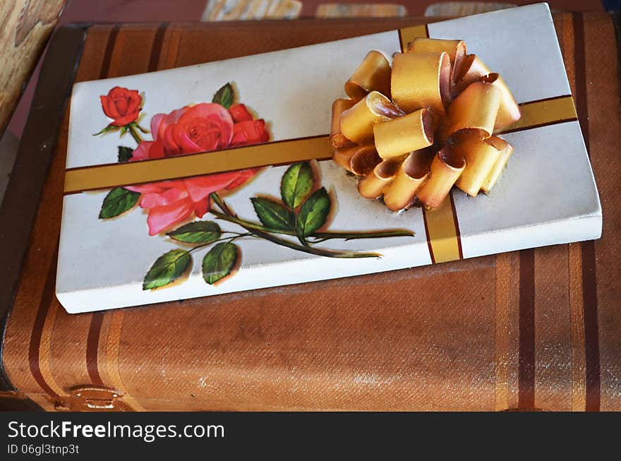 Box of chocolate seating on a suit case