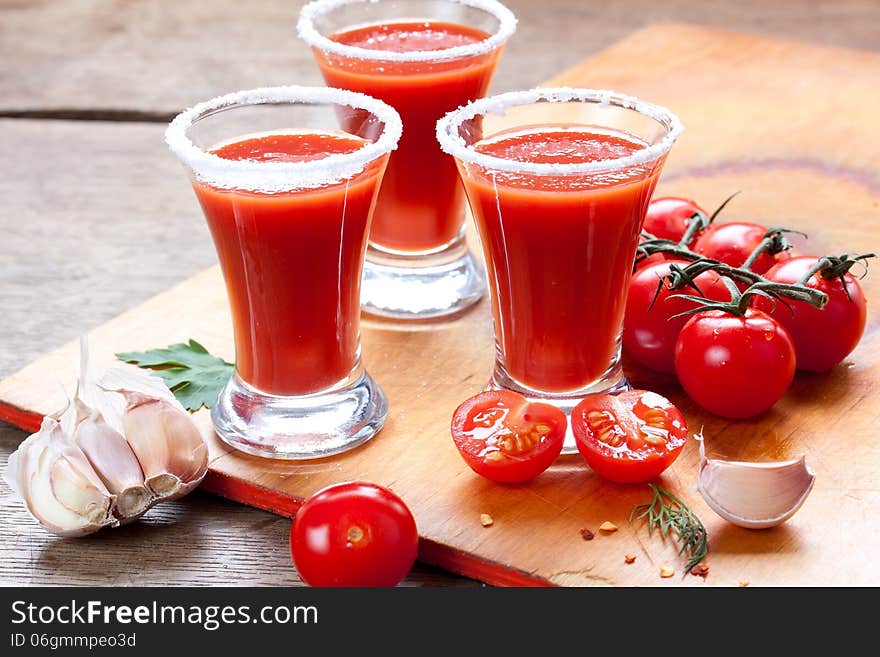 Tomato juice, tomatoes, garlic and spices on a table. Tomato juice, tomatoes, garlic and spices on a table