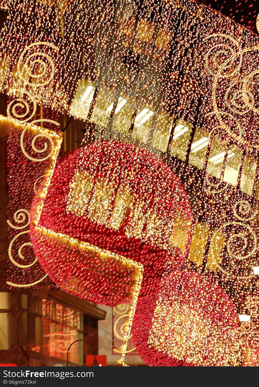 Composing of street decoration with red balls all over covered with small lights and a curtain of lights in the front of an elegant store in the city of vienna austria. Composing of street decoration with red balls all over covered with small lights and a curtain of lights in the front of an elegant store in the city of vienna austria