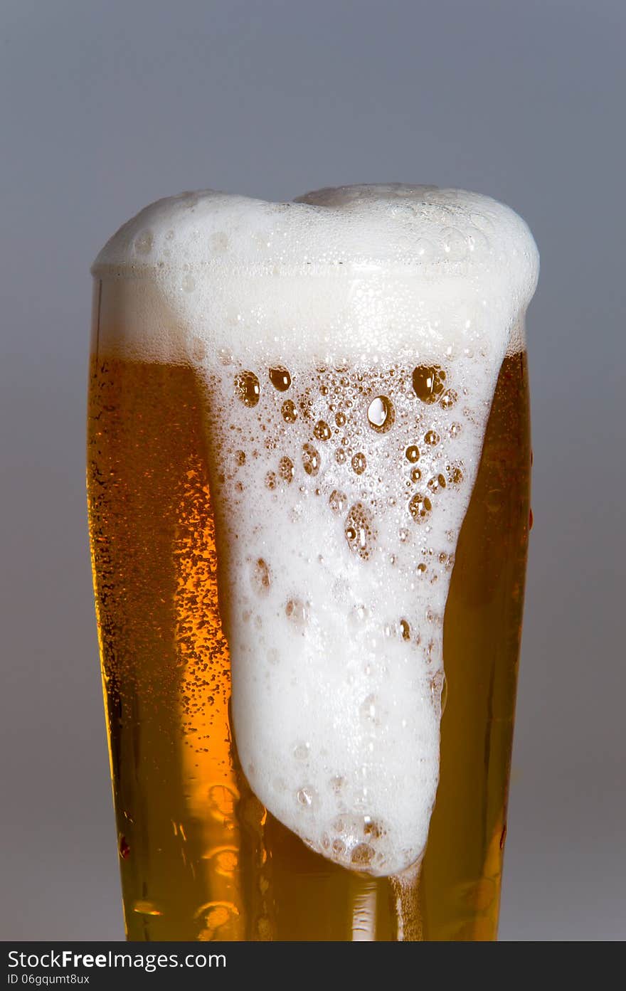 Glass of beer with foam isolated on white background