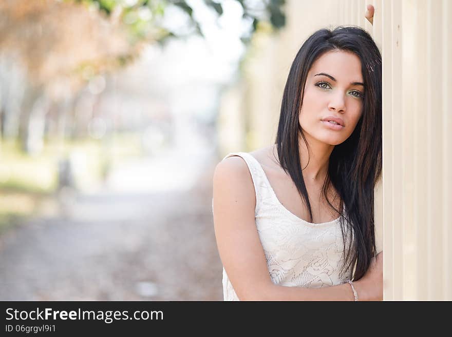 Portrait of brunette young woman with green eyes, wearing casual clothes, in urban background. Portrait of brunette young woman with green eyes, wearing casual clothes, in urban background