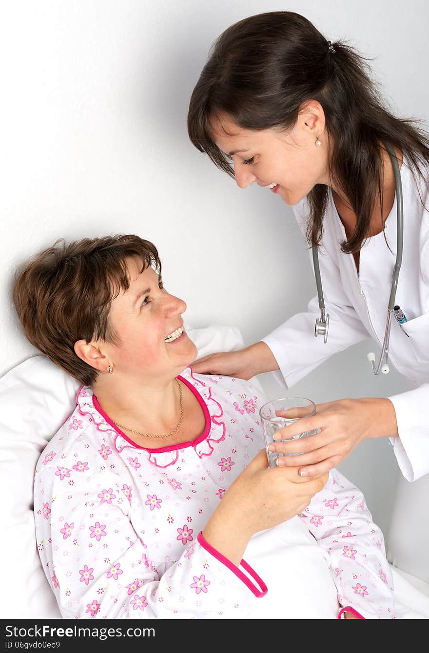 Nurse gives a glass of water to the patient