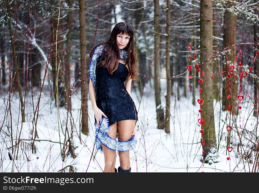 Beautiful Woman With Bright Tinsel In Winter Forest