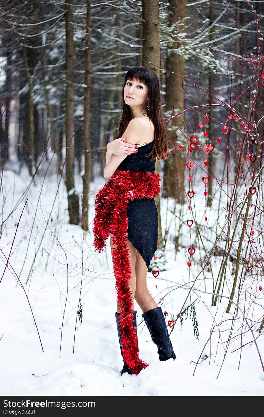 Beautiful Woman With Bright Tinsel In Winter Forest