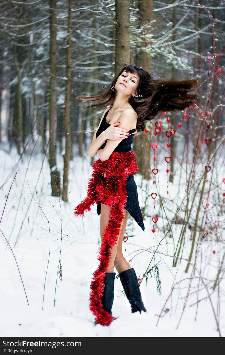 Beautiful Woman With Bright Tinsel In Winter Forest