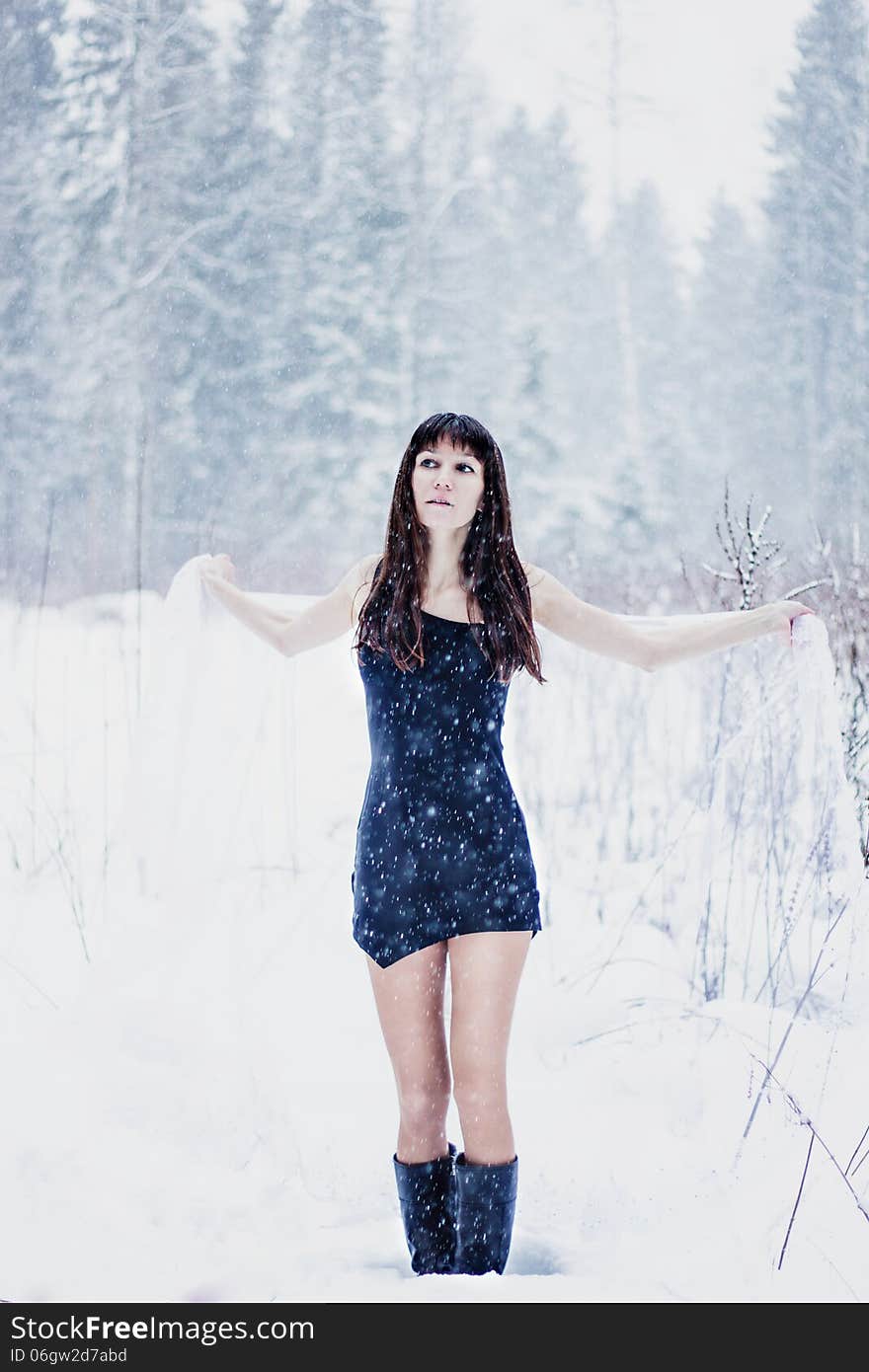 Beautiful bride under veil on white snow background