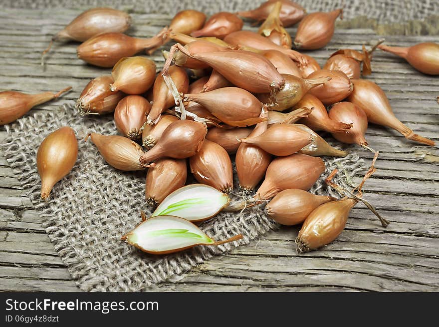 Shallot onions on a wooden and jute background