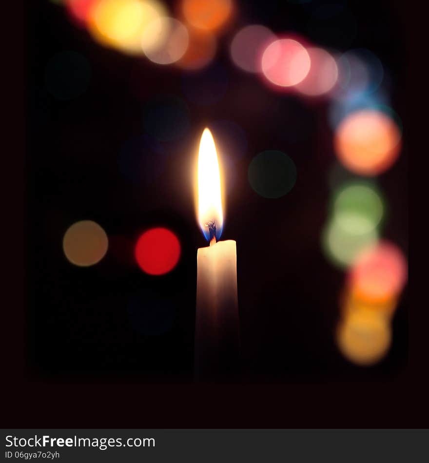 Flame Of A Candle On A Dark Background With Colored Bokeh