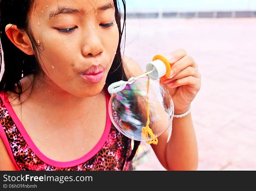 Asian girl blowing bubble at the pool. Asian girl blowing bubble at the pool