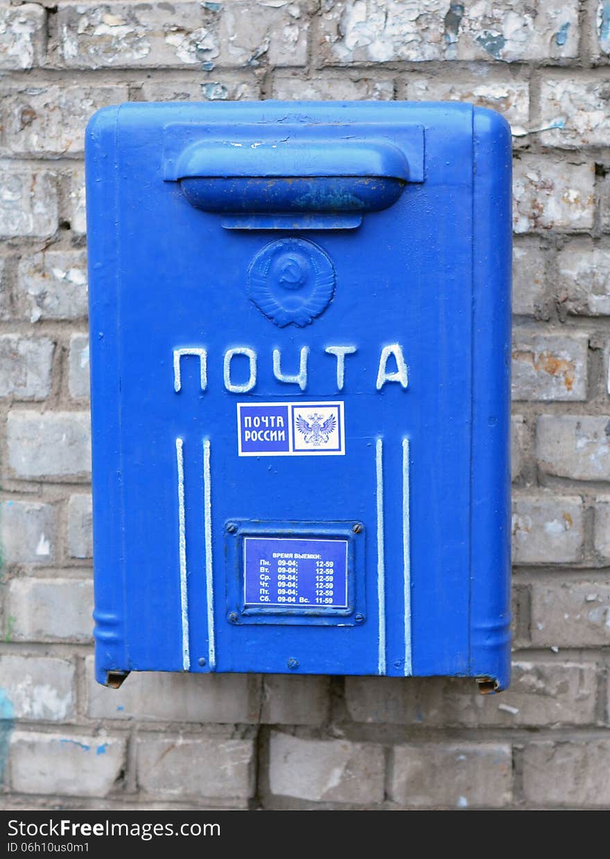 Old blue street mailbox on a building wall