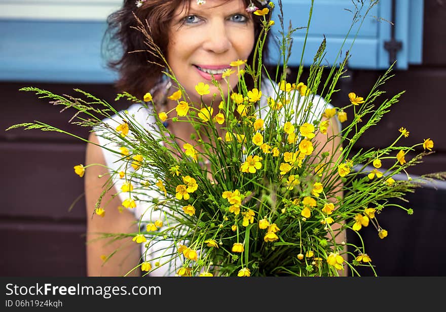 Woman looking happy behind flowers