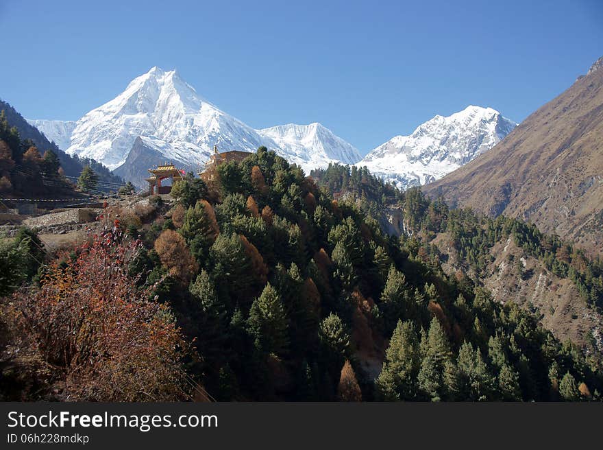 Mountain landscape with the Buddhist monastery on the background of snowy peaks