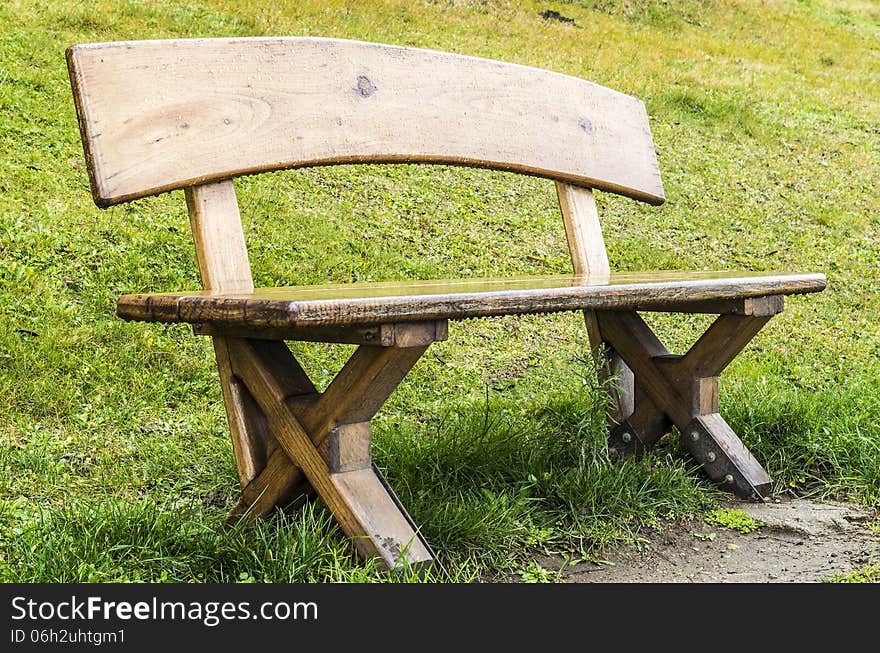 Wodden bench with green grass on background