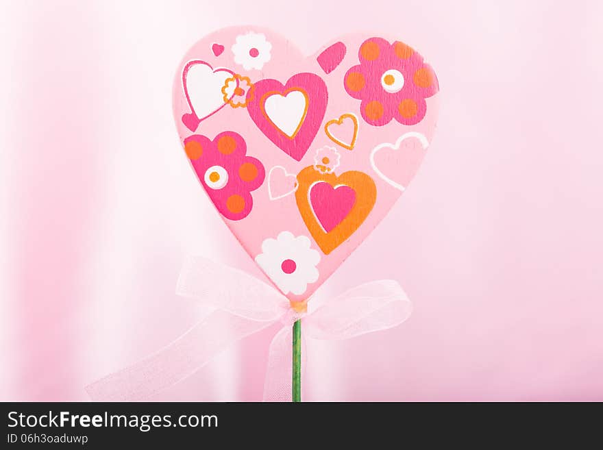 Pink handmade heart over pink background