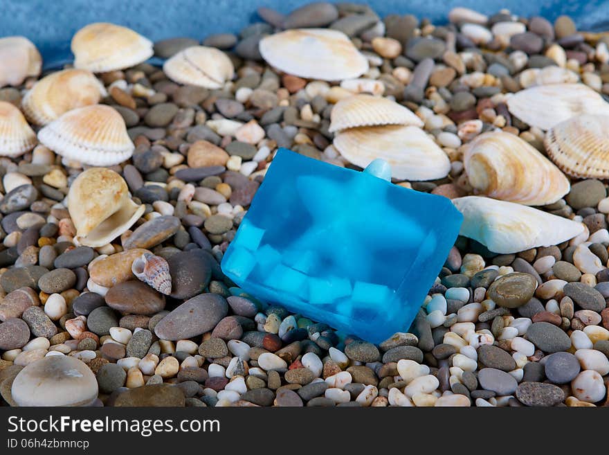 Natural skincare products of exfoliating scrub, soap and sea shells on background sea pebble. Natural skincare products of exfoliating scrub, soap and sea shells on background sea pebble