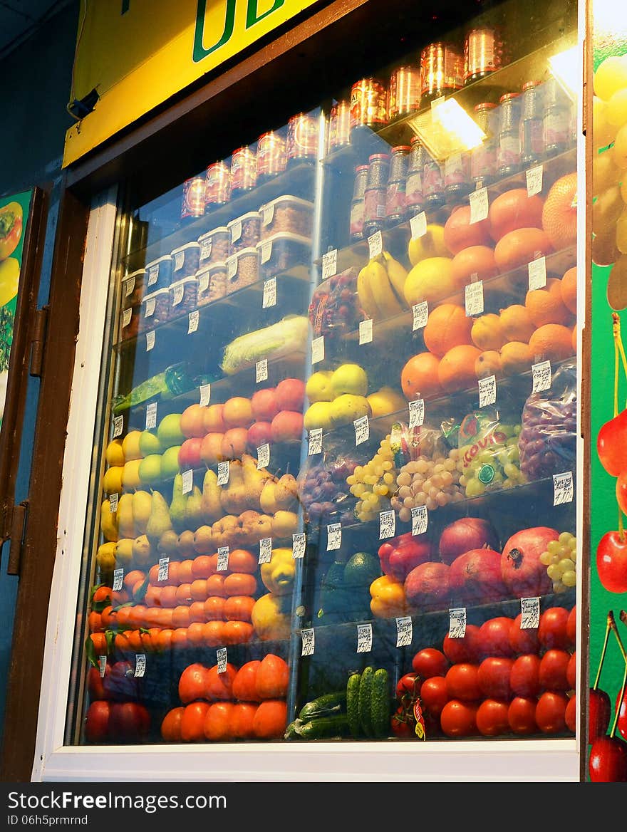 Fruit and vegetables behind the glazed show-window of a stall. Fruit and vegetables behind the glazed show-window of a stall