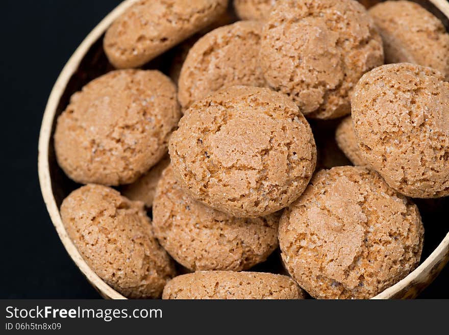 Biscotti cookies in a bowl on a black background, close-up, horizontal