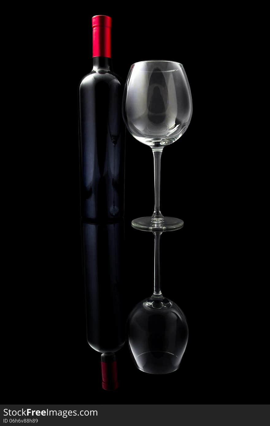 Red wine and empty glass isolated on black background