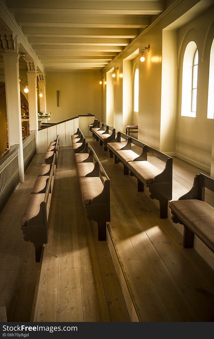 Warm natural light on lines of church pews at place of worship