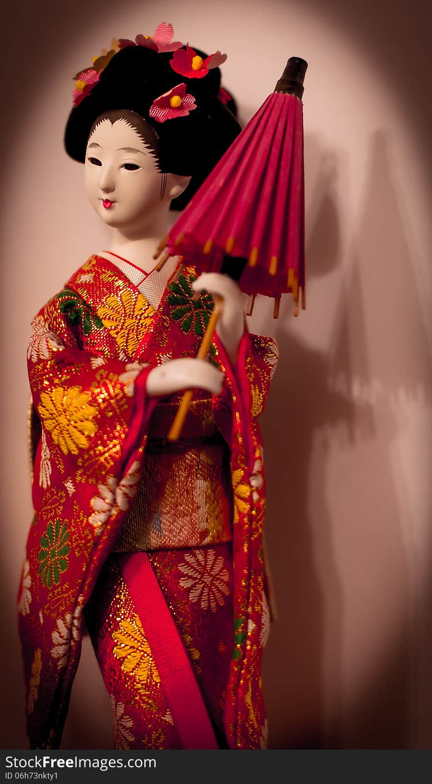 An original Japanese doll with an umbrella and flowers in hairs. An original Japanese doll with an umbrella and flowers in hairs.