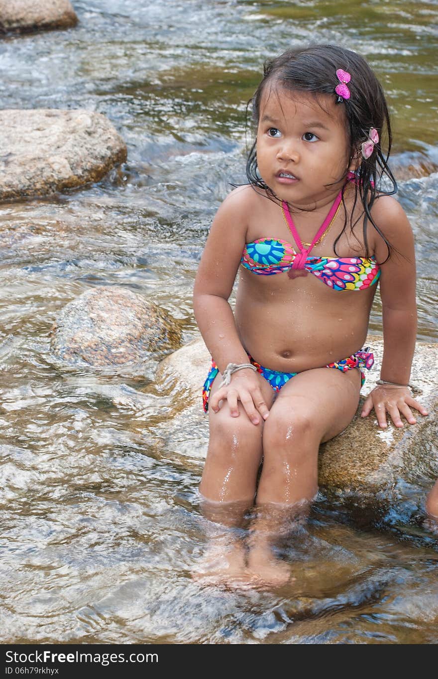 Asian girl sitting near the waterfall. Asian girl sitting near the waterfall.