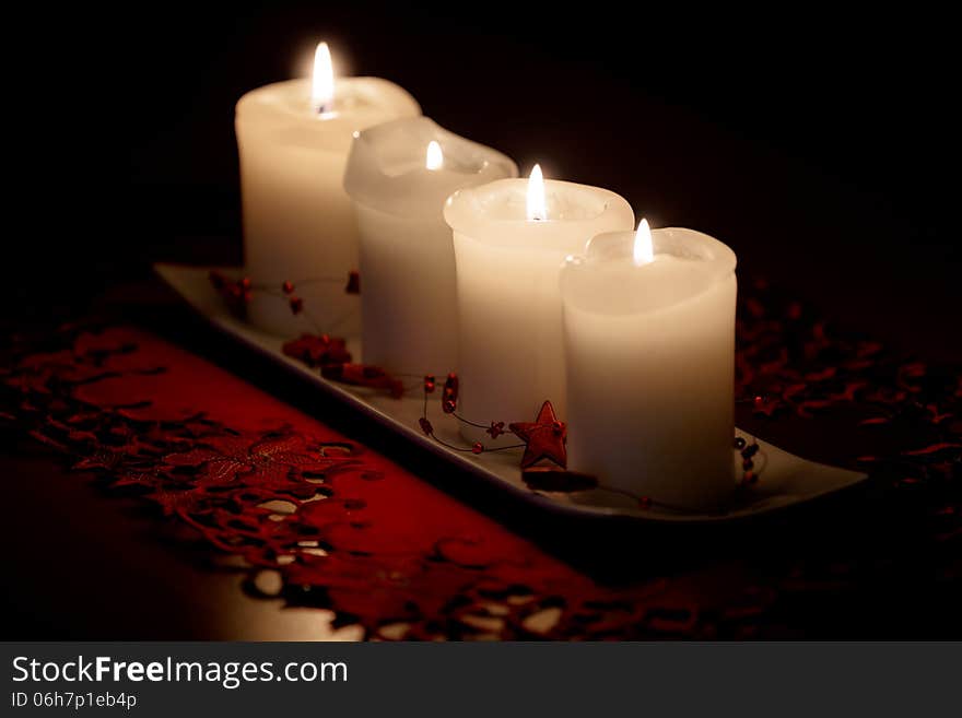 Burning candle and Christmas decorations on wooden table, on dark background. Burning candle and Christmas decorations on wooden table, on dark background