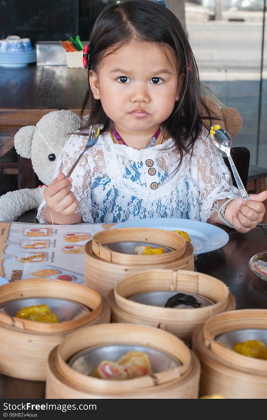 Little 2 year old girl eating Dim sum. Little 2 year old girl eating Dim sum.