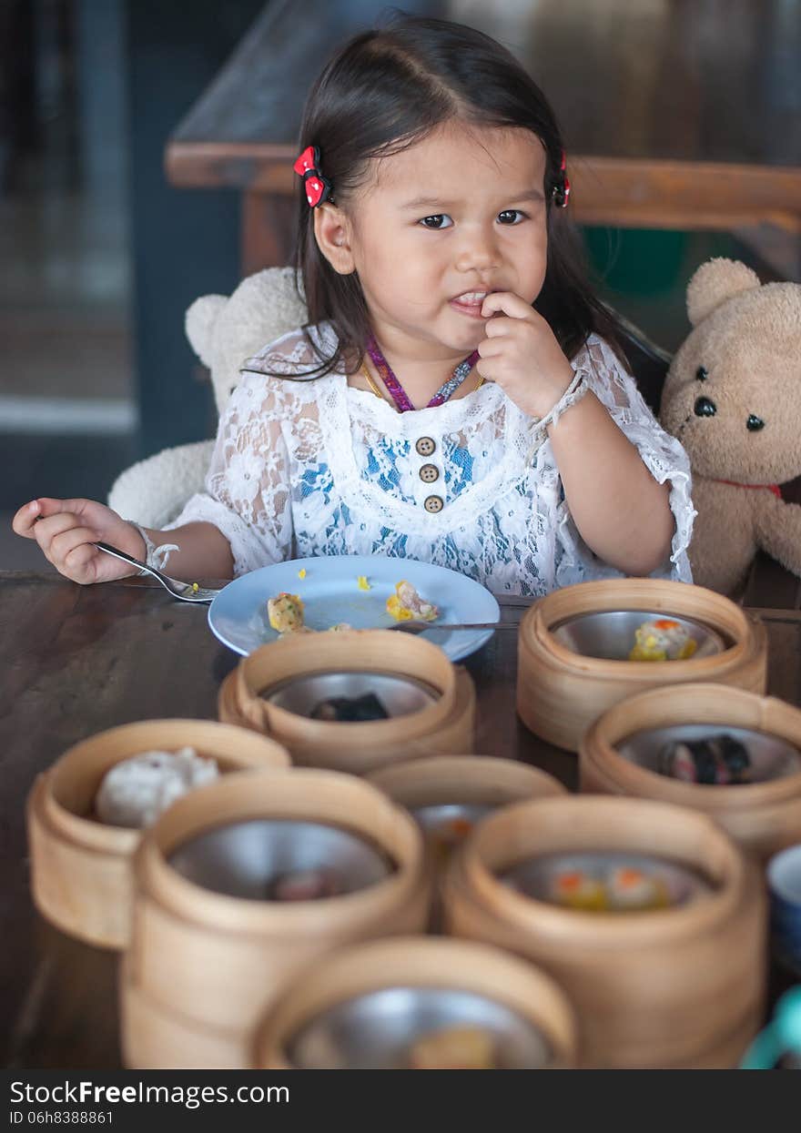 Little 2 year old girl eating Dim sum. Little 2 year old girl eating Dim sum.