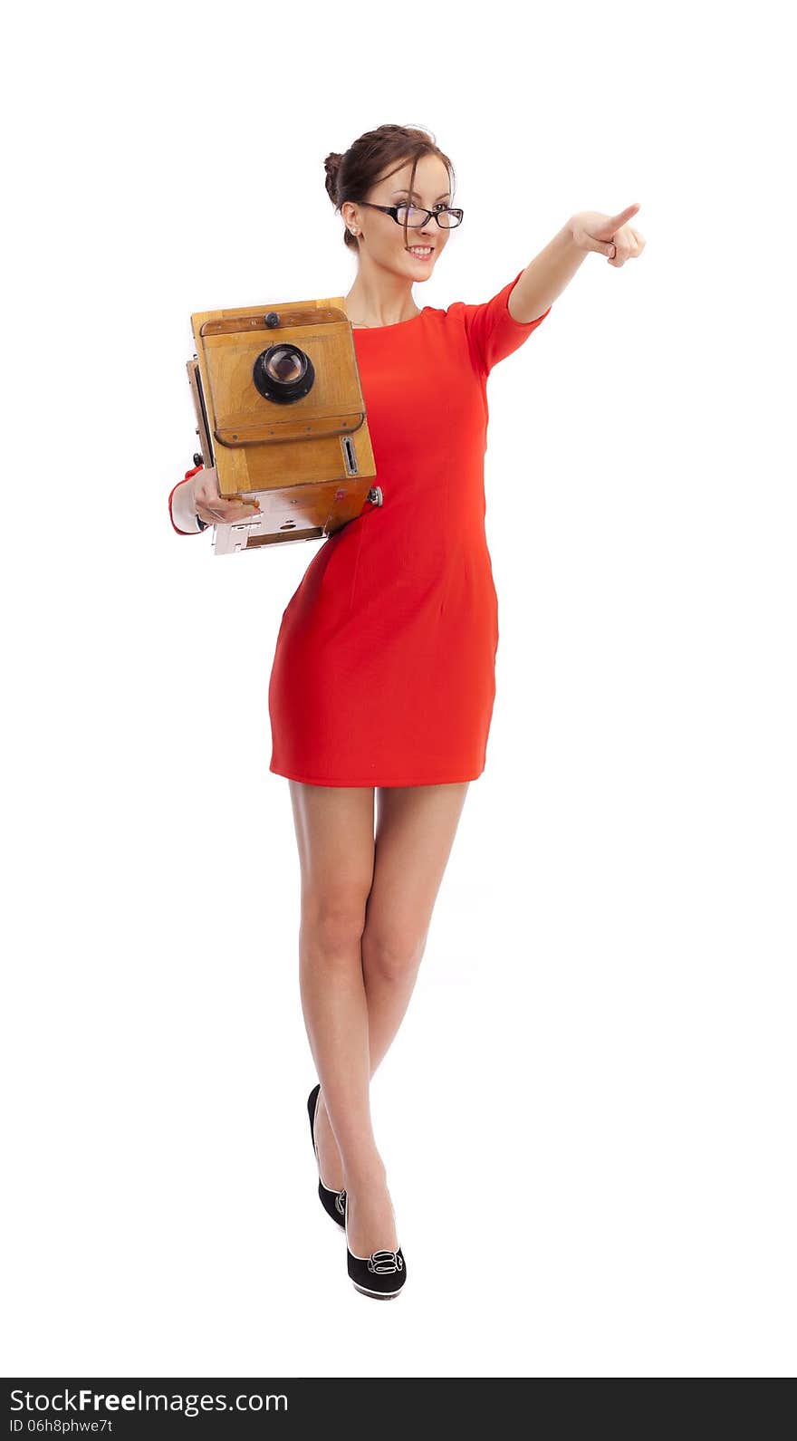 Girl in red dress with an old camera on a white background