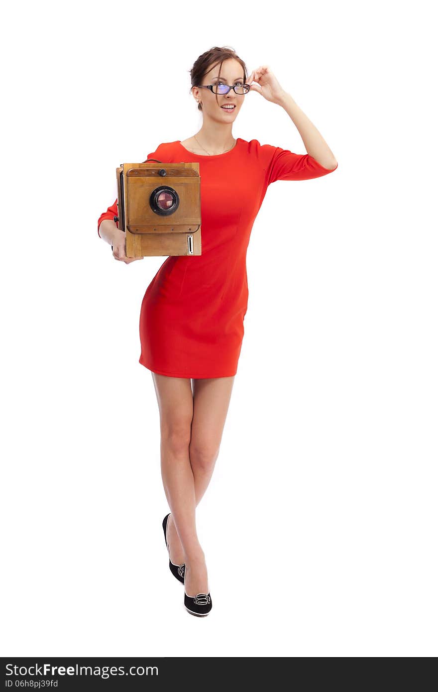 Girl in red dress with an old camera on a white background