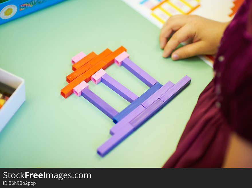 Baby gathered picture of different color sticks on the table in kindergarten. Baby gathered picture of different color sticks on the table in kindergarten