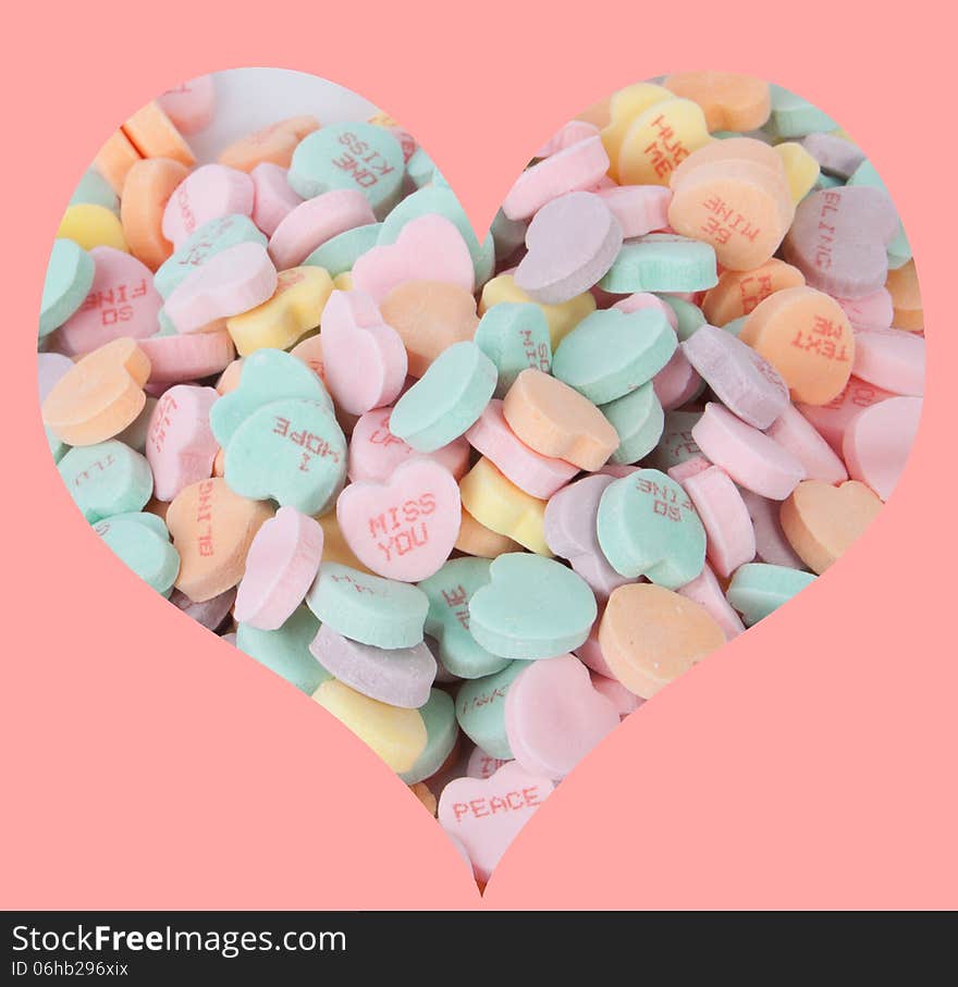 A bunch of candy hearts arranged in the shape of a heart.