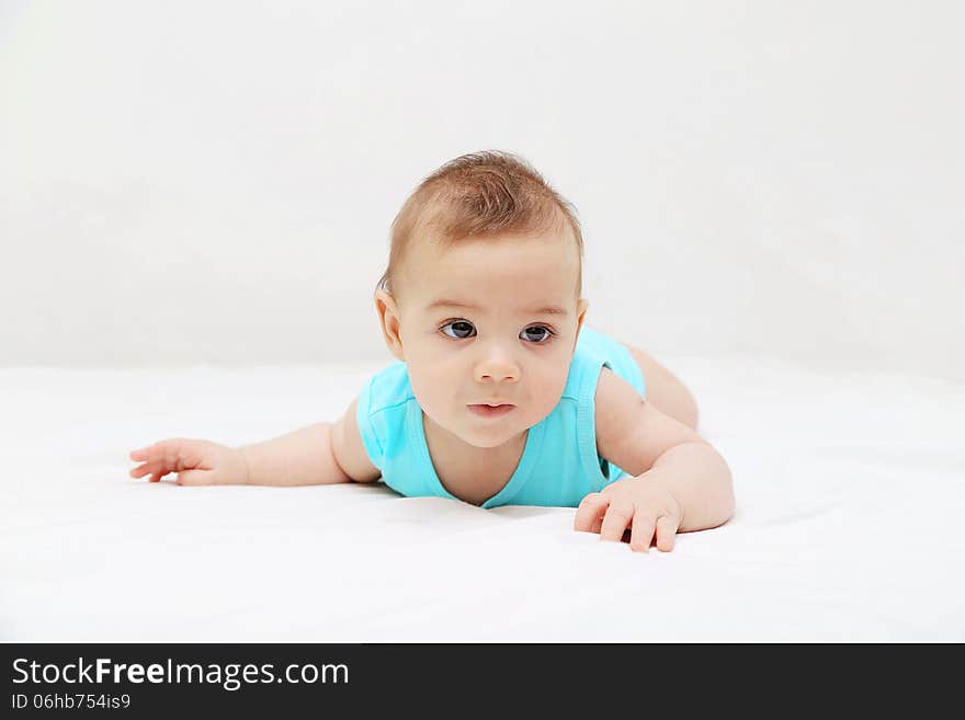 Baby boy laying on bed, white background