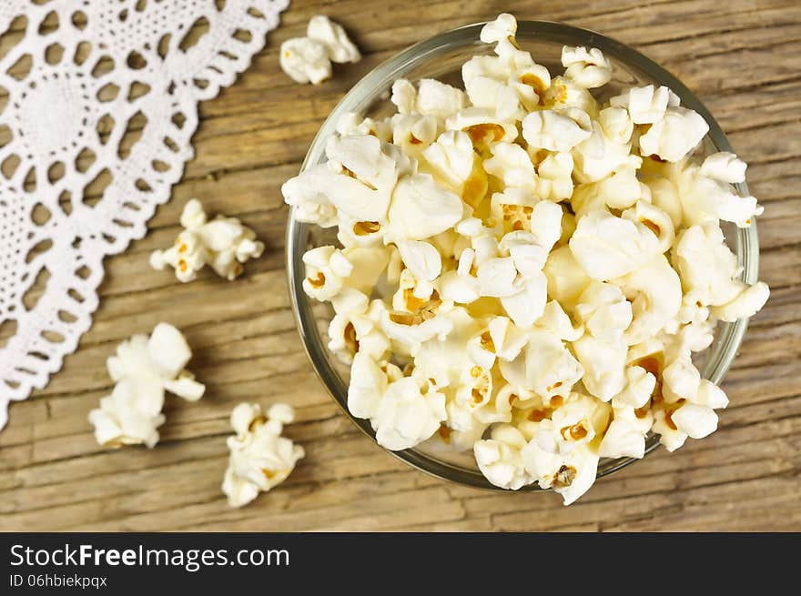 Popcorn in bowl on wooden table