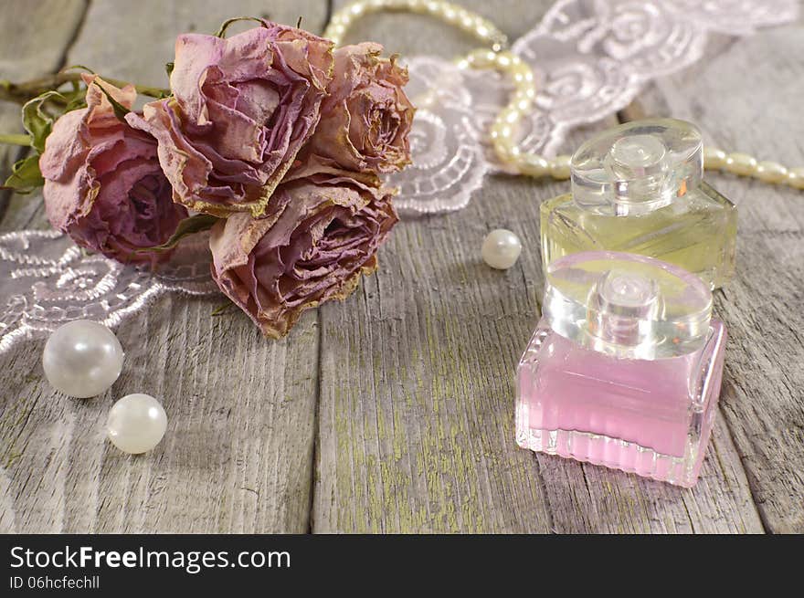 Vintage still life with pink and yellow perfume bottles on wood. Vintage still life with pink and yellow perfume bottles on wood