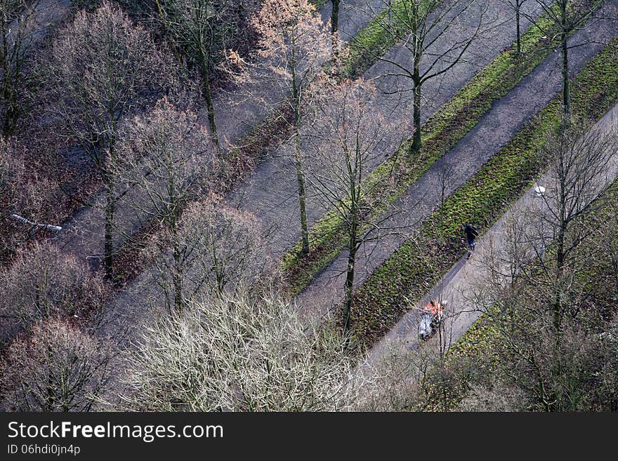 Aerial view of a four way lane in Rotterdam on a windy sunny day in December. A scooter is passing a jogger. No manipulations. Just the normal corrections without changing the colors or saturation