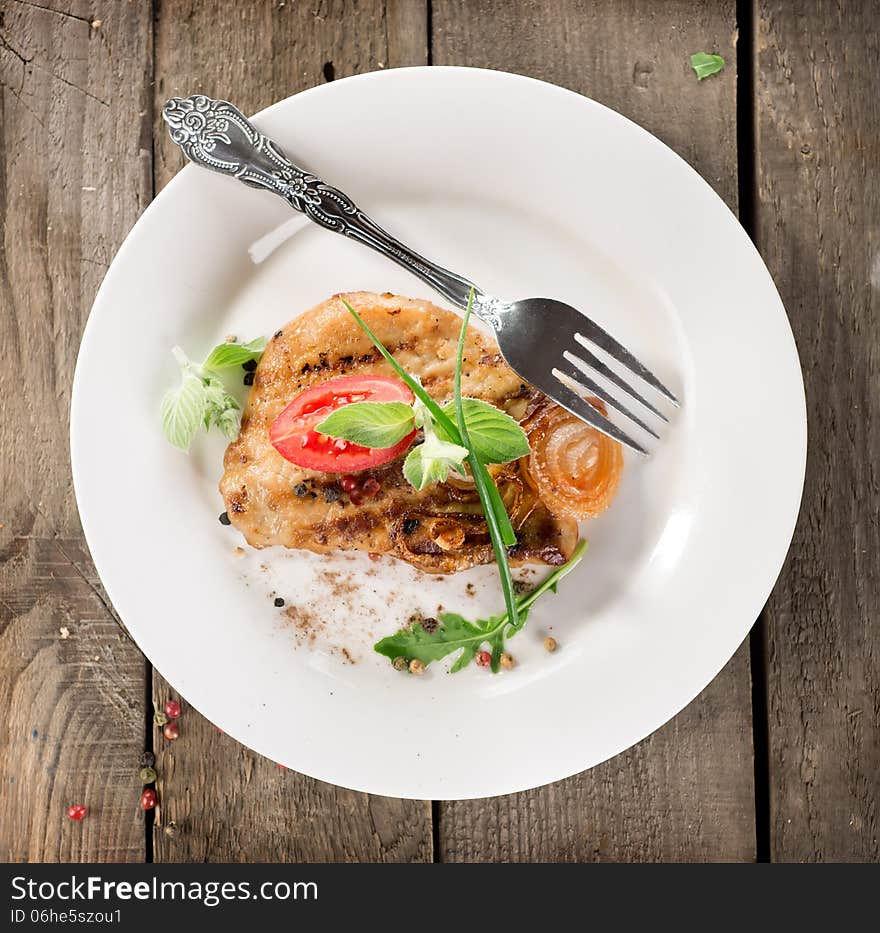 Fried meat on a plate on a wooden table