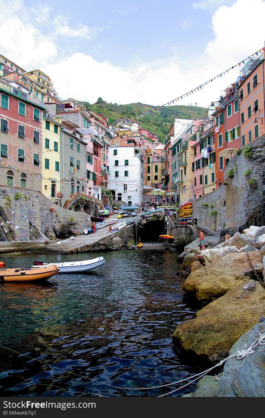 Cliff, boats and colored houses of Riomaggiore in Italy