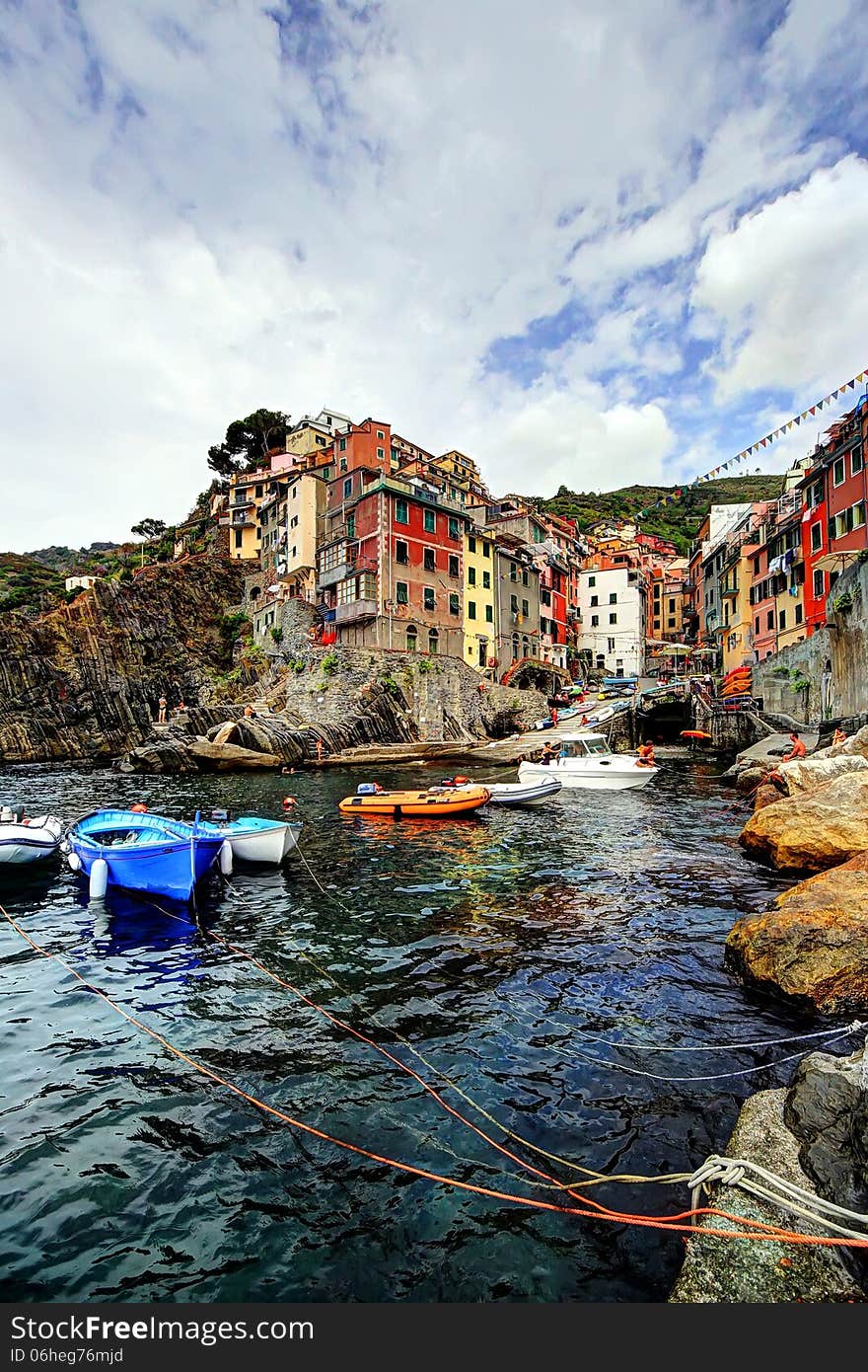 Cliff, boats and colored houses of Riomaggiore in Italy