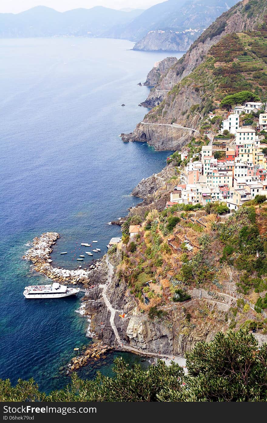 Cliff, boats and colored houses of Riomaggiore in Italy