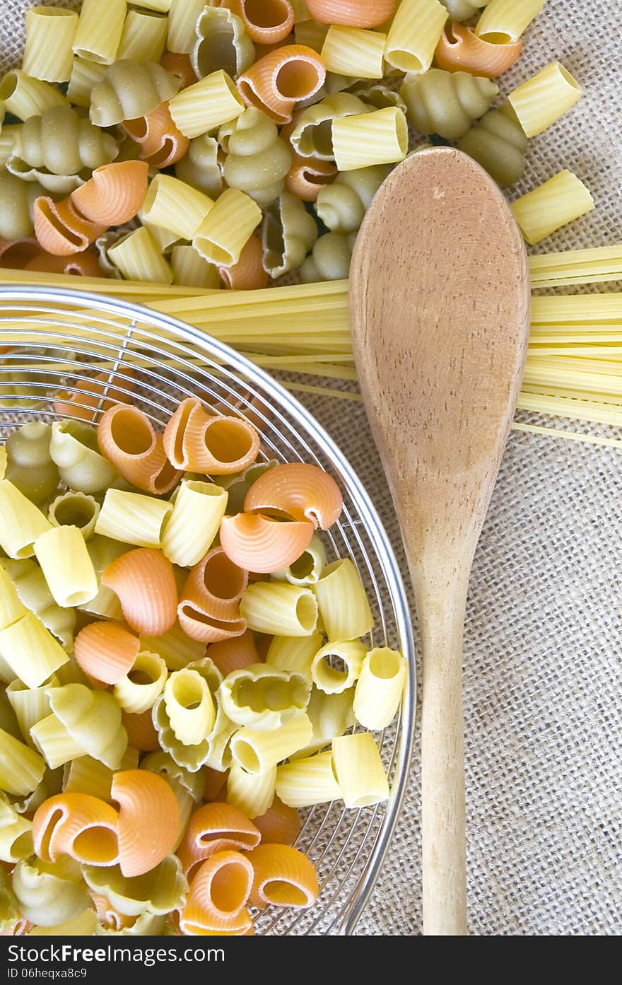 Wooden spoon and uncooked pasta