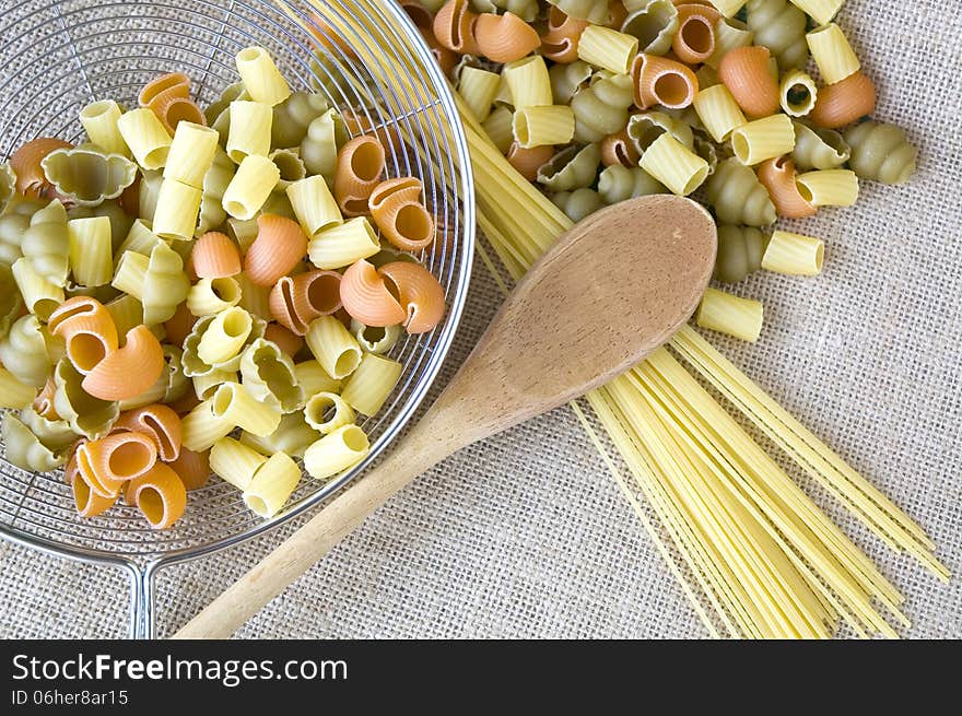 Uncooked pasta with wooden spoon